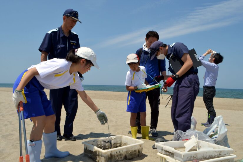 海上保安のお兄さんと浜中小学校の児童たちで一緒に調査